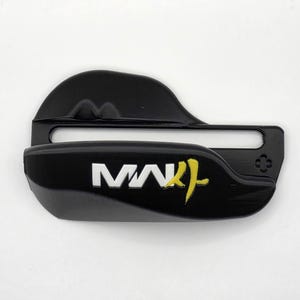 May include: A black plastic belt buckle featuring a horizontal slot and the white text "MW" followed by a yellow stylized character. The buckle has a smooth, curved surface with a small four-leaf clover-like emblem embossed on the right side.