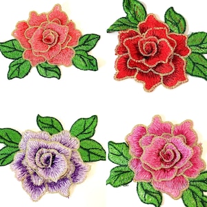 May include: Four embroidered rose patches with gold accents. The roses are in shades of pink, red, and purple. The leaves are green.