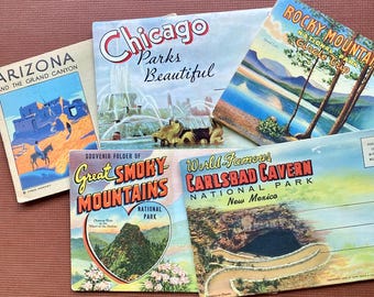 May include: A collection of vintage travel postcards featuring scenic views of national parks and landmarks. The postcards showcase colorful illustrations and text, including "Arizona," "Chicago," "Rocky Mountain," "Great Smoky Mountains," and "Carlsbad Cavern."