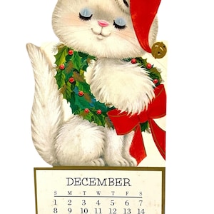 Puede incluir: Calendario navide&ntilde;o vintage con un gato blanco con gorro de Pap&aacute; Noel y una corona de acebo. El calendario muestra el mes de diciembre con fechas del 1 al 31.
