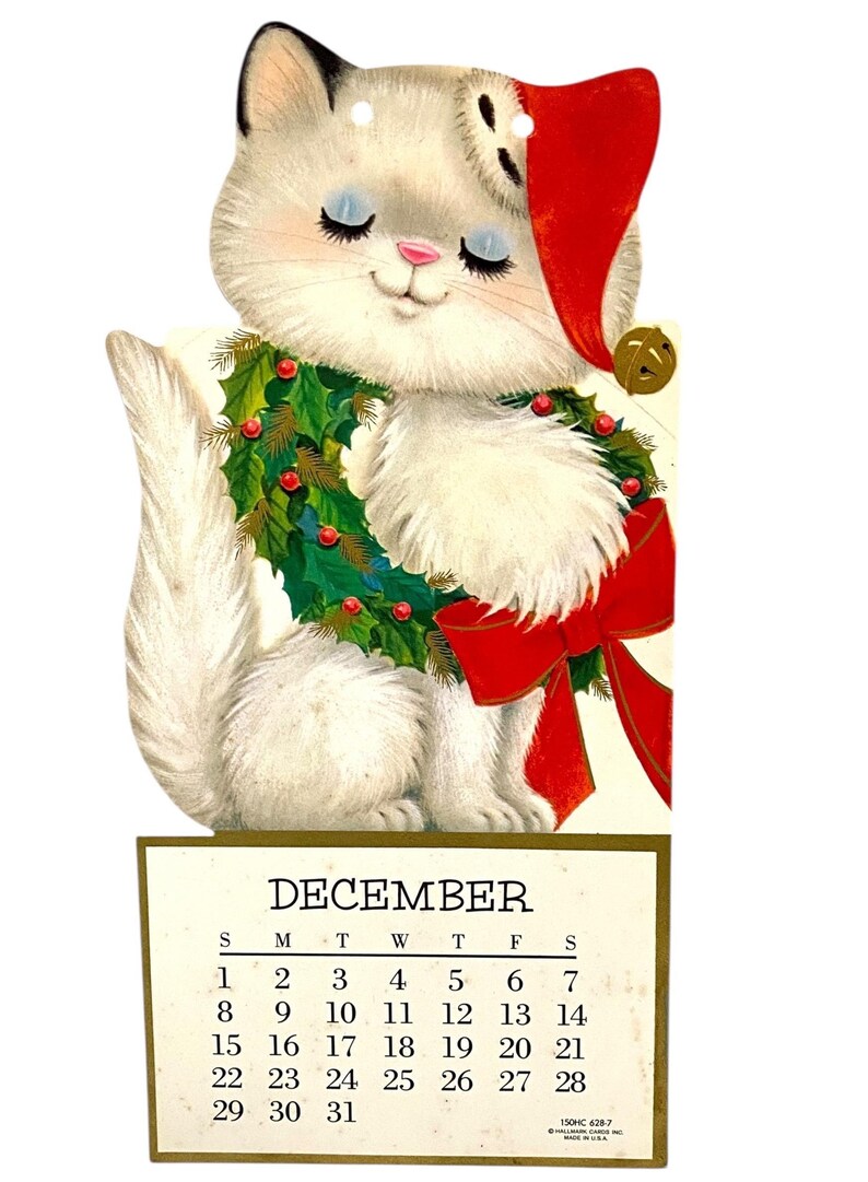 Puede incluir: Calendario navide&ntilde;o vintage con un gato blanco con gorro de Pap&aacute; Noel y una corona de acebo. El calendario muestra el mes de diciembre con fechas del 1 al 31.