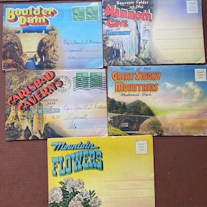 May include: A selection of vintage postcards depicting scenic locations. The postcards feature views of Boulder Dam, Mammoth Cave, Carlsbad Caverns, Great Smoky Mountains, and Mountain Flowers. Each card has a unique design and text.