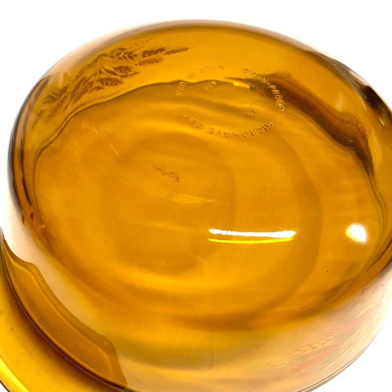 K&ouml;nnte beinhalten: Bernsteinfarbene Glassch&uuml;ssel mit runder Form. Die Sch&uuml;ssel hat eine glatte, gl&auml;nzende Oberfl&auml;che und scheint ofen- und mikrowellengeeignet zu sein. Der Text "Made in USA" ist sichtbar. Geeignet zum Servieren oder zur Zubereitung von Speisen.