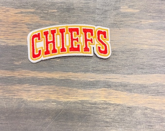 May include: A white, red, and gold embroidered patch with the word "CHIEFS" in a curved, arched font.