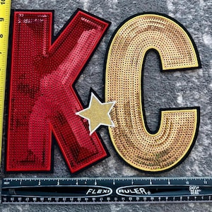 May include: Large sequined patches spelling out "KC" with a gold star accent. The "K" is red with a black border, and the "C" is gold with a black border. The "K" measures approximately 9 inches tall, and the "C" is about 8 inches tall.