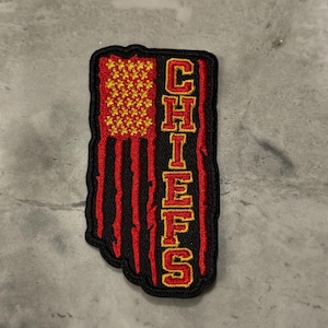 May include: A red, white, and blue American flag patch with the word "CHIEFS" embroidered in yellow on the right side.