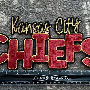 Puede incluir: Parche de los Kansas City Chiefs rojo y dorado con un diseño de lentejuelas.