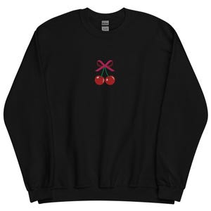 May include: Black sweatshirt with a pink bow and two red cherries embroidered on the front.