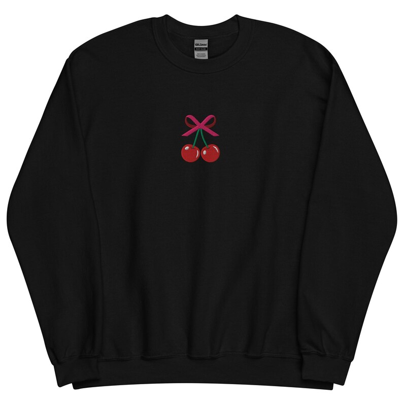 May include: Black sweatshirt with a pink bow and two red cherries embroidered on the front.