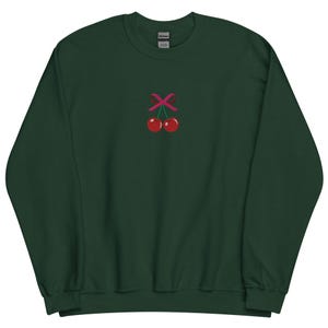 May include: A dark green sweatshirt with a pink ribbon and two red cherries embroidered on the front.