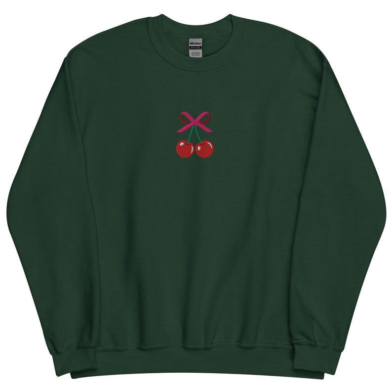 May include: A dark green sweatshirt with a pink ribbon and two red cherries embroidered on the front.