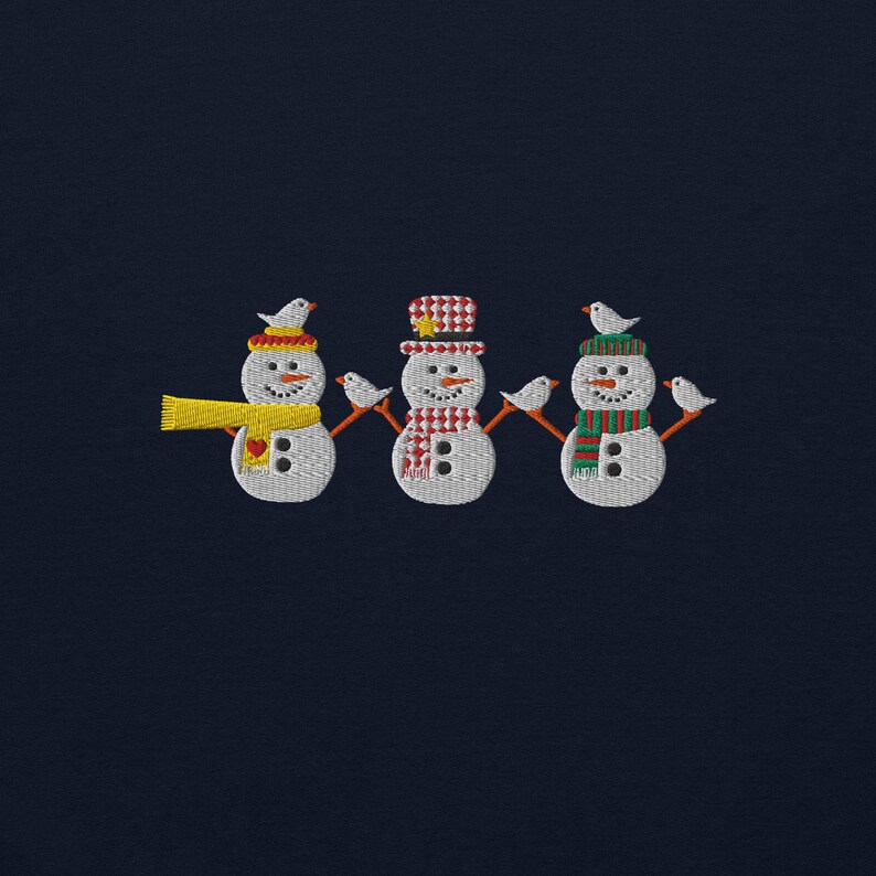 Celebrate the magic of the holidays with this Festive Snowmen Embroidered Sweatshirt, featuring a delightful trio of snowmen and adorable birds. ❄️☃️ Perfect for cozying up by the fire, holiday parties