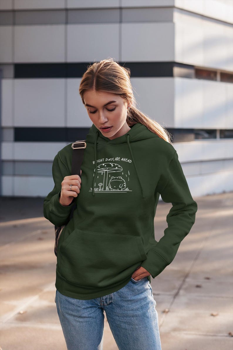 Threadmire © - Get ready to hop into cozy vibes with our Embroidered Cute Frog Under Mushroom Shirt, a whimsical nature tee that’s perfect for animal lovers and those who appreciate positive quotes! This delightful sweatshirt not only keeps you comfy
