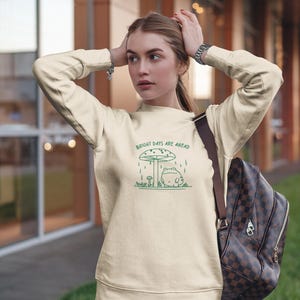 Threadmire © - Get ready to hop into cozy vibes with our Embroidered Cute Frog Under Mushroom Shirt, a whimsical nature tee that’s perfect for animal lovers and those who appreciate positive quotes! This delightful sweatshirt not only keeps you comfy