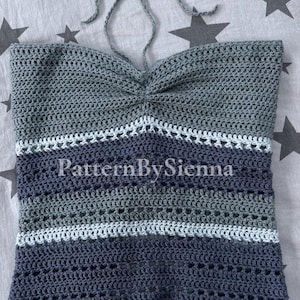 May include: A crocheted halter top with a blue and gray striped pattern. The top has a gathered neckline and a scalloped hem.