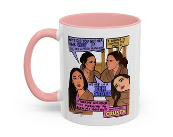 May include: A white ceramic mug with a light pink handle and interior rim. The exterior features a colorful comic-style illustration of three people in brown robes with speech bubbles containing text about hair, zen states, and feeling crusty.