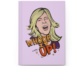 May include: A light purple hardcover journal featuring a cartoon illustration of a blonde person with an open mouth and closed eyes. The text WHOOP IT UP! is printed in large orange letters with a black outline below the illustration.