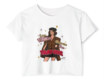 May include: A white short-sleeved t-shirt featuring a graphic illustration of a person in a leopard print jacket and black beret. The text reads "I am TINKin there are tree TRAY-ERS" surrounded by small star icons in pink, yellow, and white.
