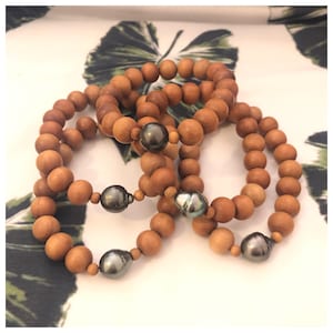 Peut inclure: Trois bracelets en perles de bois avec des accents de perles noires. Chaque bracelet a une seule perle.