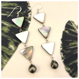 May include: A pair of silver earrings with three triangular shaped iridescent shell pendants and a black pearl at the bottom of each earring.