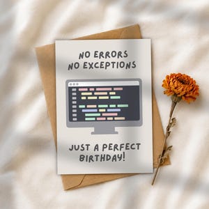May include: A white greeting card featuring a grey computer monitor graphic displaying colourful code snippets. The text reads NO ERRORS NO EXCEPTIONS at the top and JUST A PERFECT BIRTHDAY! at the bottom. A brown envelope is positioned behind the card.