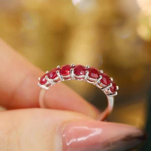 Pu&ograve; includere: Un anello color argento caratterizzato da una fila di sette rubini rotondi di colore rosso intenso, montati con griffe. La fascia &egrave; sottile e metallica, mettendo in mostra una serie di vivaci gemme sfaccettate disposte orizzontalmente.