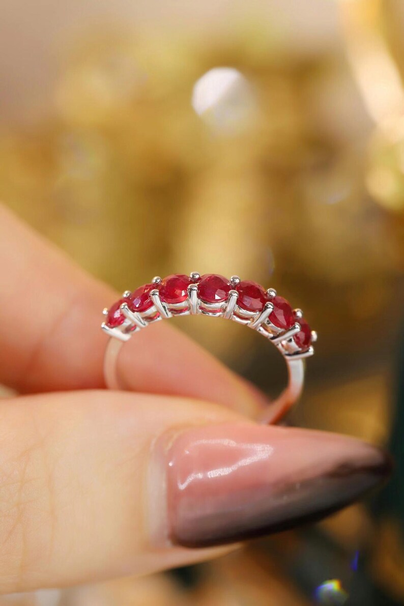 Pu&ograve; includere: Un anello color argento caratterizzato da una fila di sette rubini rotondi di colore rosso intenso, montati con griffe. La fascia &egrave; sottile e metallica, mettendo in mostra una serie di vivaci gemme sfaccettate disposte orizzontalmente.