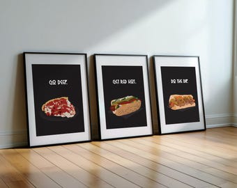 May include: Three framed art prints with black backgrounds and white text. The prints feature illustrations of food items: a slice of pizza, a hot dog, and a sandwich. The text on the prints reads "GO DEEP", "GET RED HOT", and "DO THE DIP".