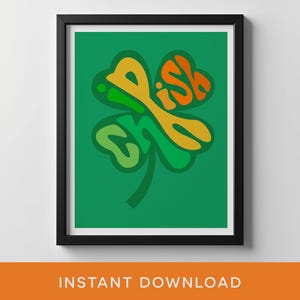 以下が含まれることがあります： オレンジと黄色で「Irish」の文字が入った緑のクローバーが描かれた、額入りのアートプリント。アートワークは緑色の背景に配置され、黒いフレームに入っています。「INSTANT DOWNLOAD」の文字が下部にあります。