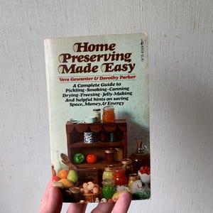 May include: A vintage cookbook titled "Home Preserving Made Easy" by Vera Gewanter & Dorothy Parker. The cover features a wood shelf with jars of preserved food and a variety of fruits and vegetables.
