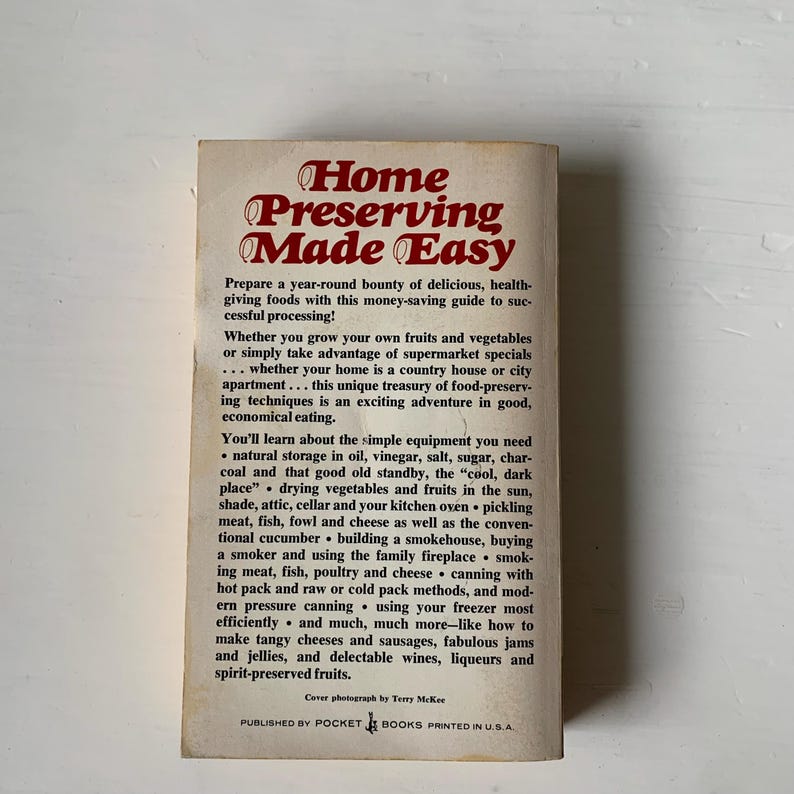May include: A vintage book cover with a red and white title "Home Preserving Made Easy". The cover features a simple design with a white background and red text. The book is about preserving food at home.