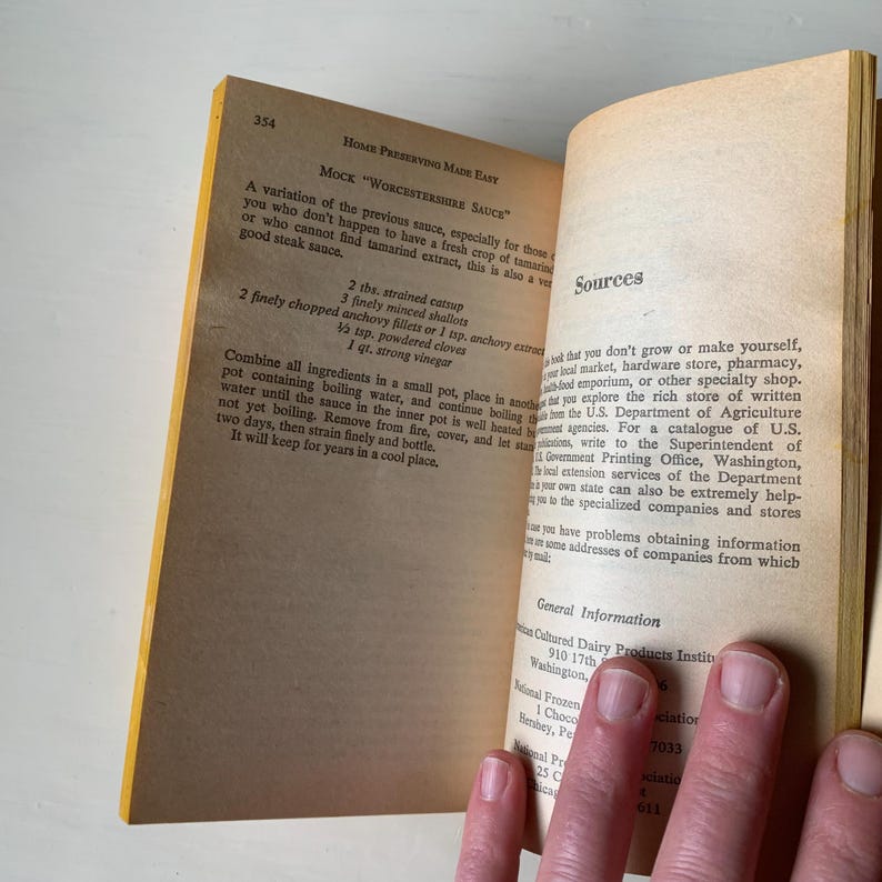 May include: A yellow and white book titled "Home Preserving Made Easy" with a recipe for Mock "Worcestershire Sauce" and a list of sources for information on food preservation. The recipe includes ingredients such as strained ketchup, minced shallots, anchovy fillets, powdered cloves, and strong vinegar.
