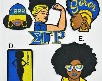 May include: Five embroidered iron-on patches featuring black women with yellow and blue accents. The patches include the letters "ΣΓΡ", the year "1922", and the word "Soror".