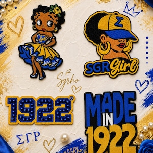 Könnte beinhalten: Vier bestickte Aufnäher in Blau und Gold. Einer zeigt eine Zeichentrickfigur in einem Kleid, ein anderer eine Person mit Baseballkappe und dem Text SGR Girl, einer zeigt die Zahl 1922 und der letzte trägt die Aufschrift Made In 1922.