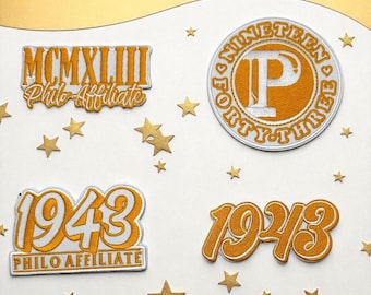 Peut inclure: Quatre écussons brodés en or et blanc. Les écussons présentent les textes "MCMXLIII Philo Affiliate", "1943 Philo Affiliate", "1943", et un écusson circulaire avec "NINETEEN FORTY-THREE P". Des étoiles dorées ornent les écussons.
