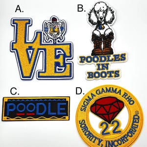 May include: Four embroidered patches with different designs. The first patch is yellow with blue trim and says "LOVE". The second patch is white with a poodle wearing boots and says "POODLES IN BOOTS". The third patch is yellow with blue trim and says "POODLE". The fourth patch is yellow with blue trim and says "SIGMA GAMMA RHO SORORITY, INCORPORATED" with a red diamond and the number "22" in the center.