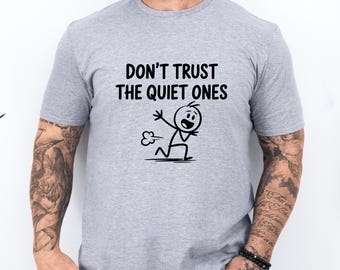 May include: A light gray t-shirt with the text "DON'T TRUST THE QUIET ONES" above a stick figure illustration. The stick figure is running and emitting a cloud of gas.