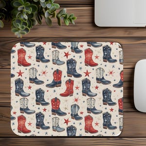 May include: A square mouse pad featuring a repeating pattern of cowboy boots in shades of red, navy blue, and white, interspersed with small red and blue stars on a cream-colored background. The design showcases various boot styles.