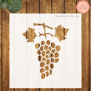May include: A stencil featuring a grape cluster design with leaves and vines. The stencil is made of a light brown material and is set against a white background. The text "Stencils & Crafts Inc." is printed on the white background.