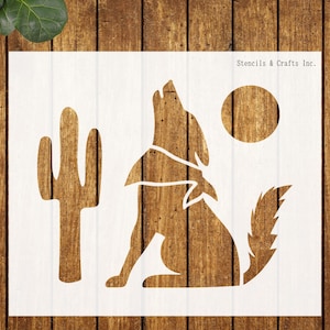 May include: A white stencil featuring a howling wolf, a cactus, and a full moon. The wolf is silhouetted against a wooden background. The text "Stencils & Crafts Inc." is in the upper right corner.