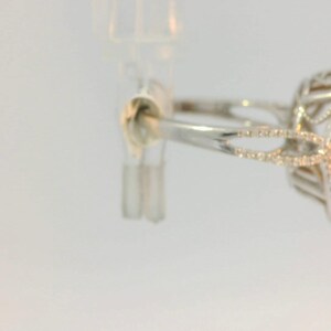 May include: A silver ring with a large, oval-shaped opal gemstone set in a delicate, diamond-encrusted setting.