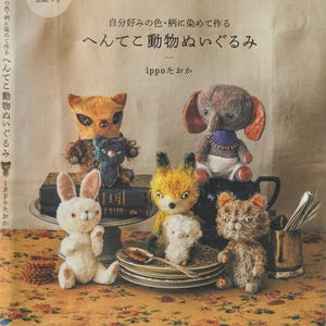 May include: A book cover featuring handmade stuffed animal toys, including a cat, elephant, fox, and rabbit. The book title is in Japanese, with the author's name, and includes a tag that says "actual size pattern included."