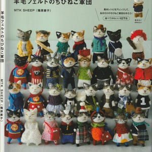 May include: A book titled "羊毛フェルトのちびねこ軍団 MTK SHEEP (篠原素子)" featuring a collection of 107 felted cat figurines in various poses and outfits. The cats are wearing hats, scarves, dresses, and other accessories. The book cover is illustrated with a colorful array of felted cats.