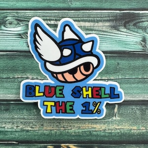 May include: A sticker featuring a blue shell character with white wings and a peach-colored face. The text "BLUE SHELL THE 1%" is written in colorful block letters on a light blue background, outlined in white.