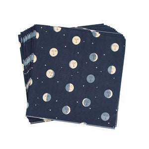 May include: A stack of blue paper napkins with a white moon and star pattern.