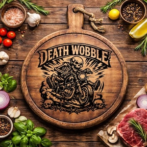 Puede incluir: Una tabla de cortar redonda de madera con un asa, con un gráfico negro de un esqueleto montando una motocicleta con el texto "DEATH WOBBLE". La tabla está rodeada de varios ingredientes como tomates, ajo y hierbas.