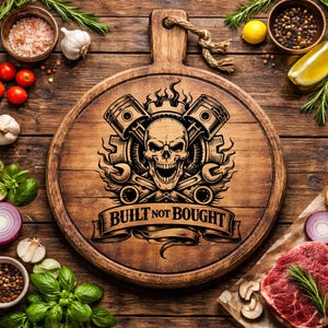 May include: A round wooden cutting board with a handle, featuring a skull and pistons design with the text "BUILT NOT BOUGHT". The board is surrounded by fresh ingredients like tomatoes, garlic, and herbs, suggesting a culinary theme.