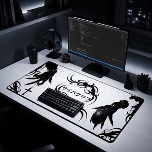 May include: White desk mat with a black and white graphic design, a keyboard, and a mouse. The mat features a stylized illustration and Japanese text. A computer monitor, headphones, and other accessories are also on the desk.