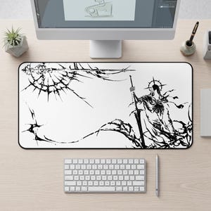 Może przedstawiać: Prostokątna czarno-biała podkładka pod mysz z szczegółową ilustracją postaci z mieczem i aureolą. Projekt zawiera efekt pękniętego szkła. Widoczna jest biała klawiatura i rysik.