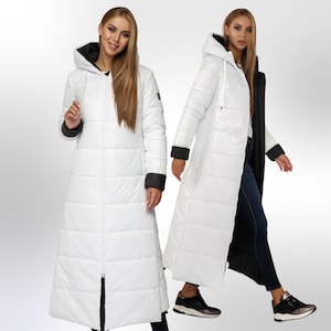 May include: A white long puffer coat with a black hood and black trim on the sleeves. The coat has a zip closure and a quilted design.